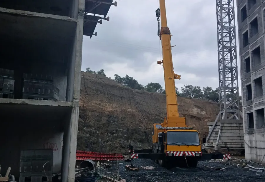 Yüksek katlı inşaat sahasında çalışan sarı mobil vinç